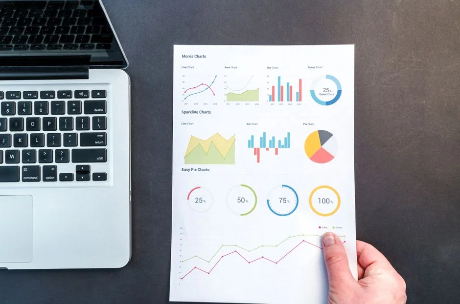 Une vue de dessus de documents et de graphiques liés à la stratégie marketing, disposés sur un bureau et illustrant la planification d’entreprise.